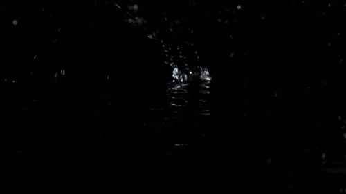Large Drops of Rain Fall on the Black Water Forming Rippling Surface of the Water. Black Background