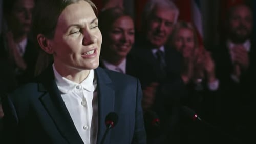 Woman Speaking at Podium in Front of Audience