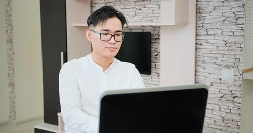 Young Adult Working on Laptop at Home
