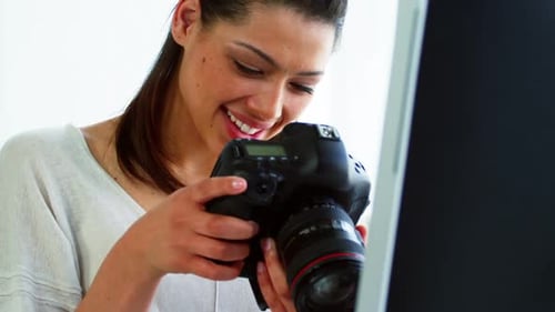 Smiling Woman Looking at Digital Camera in Office