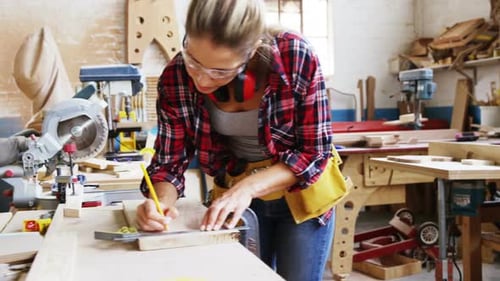 Woman Measures Wood in Sunny Workshop
