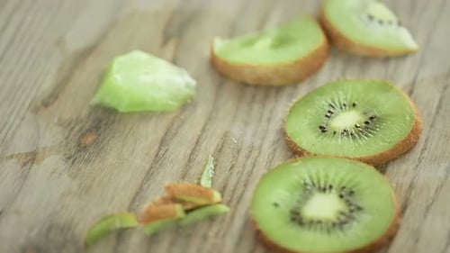 Time-lapse. Slicing orgenic kiwi on wood cutting board.