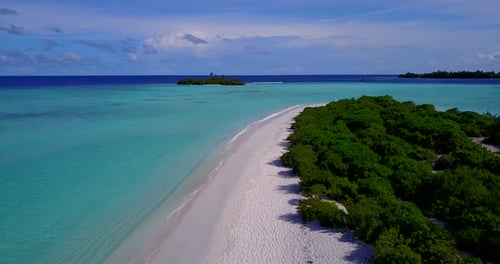 Daytime fly over clean view of a white sand paradise beach and aqua blue ocean background