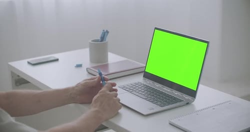 Aged Man Is Using Laptop for Communication, E-learning and Viewing Webinar, Green Screen for Chroma