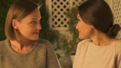 Two Women Talking and Laughing Together at Night