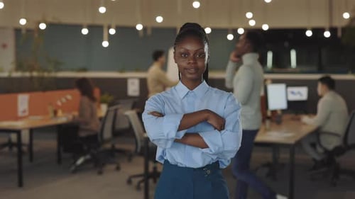 Young African American Handsome Businesswoman Looking at the Camera Standing in Modern Office with