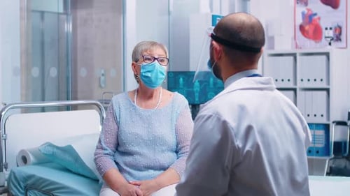 Senior Woman Consults Doctor in Hospital Room