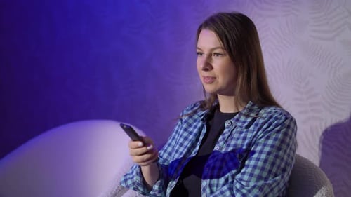 Young Woman Watching TV with Remote