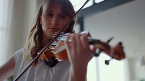 Woman Plays Violin in Indoor Setting