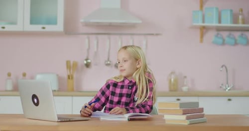 Blonde Girl Studying at Table With Laptop