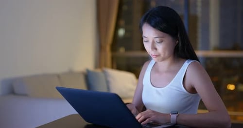 Woman Using Laptop at Home at Night