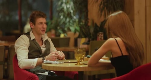 Loving Couple is Sitting in a Restaurant at a Table