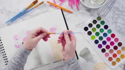 Watercolor Painting of Birthday Cakes and Art Supplies