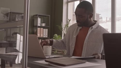 Man Works at Laptop in Modern Office