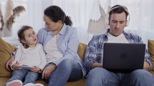 Family Relaxing on Couch with Technology