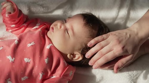 Parental Hands Tenderly Caress Infant's Head
