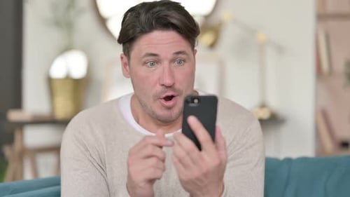 Man Celebrates While Looking at His Phone