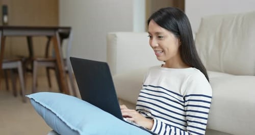 Woman Using Laptop on Floor at Home