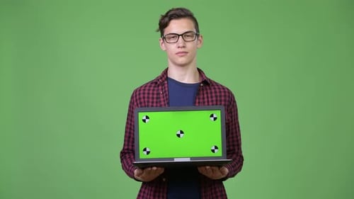Young Adult Holds Laptop with Chroma Key Screen