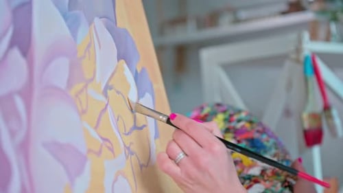 Young Woman Artist Painting Picture on Canvas in Art Workshop Close Up