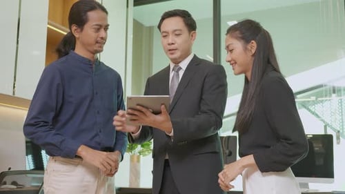 Team Collaborating on Tablet in Modern Office