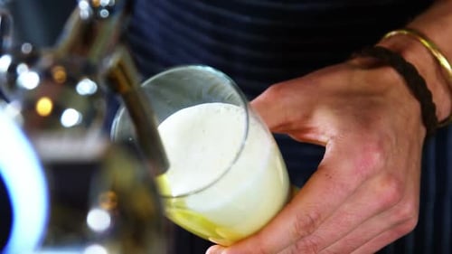 Waiter pouring beer from beer tap