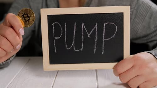 Closeup of a Woman Holding a Board with the Inscription PUMP and a Gold Bitcoin