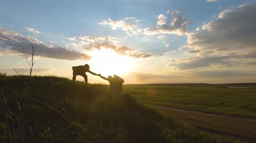 Silhouette of the Team on the Peak of Mountain. Sport and Active Life of People. Teamwork Assistance