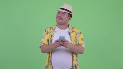 Man in Hat Types on Phone, Looks Up