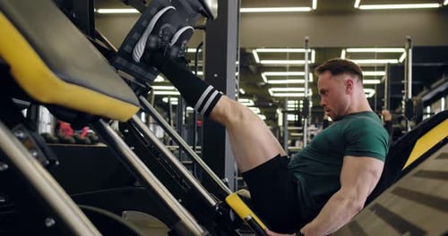 A Young Pumped Up Athlete Does Another Leg Exercise In The Gym In Preparation For Competition.