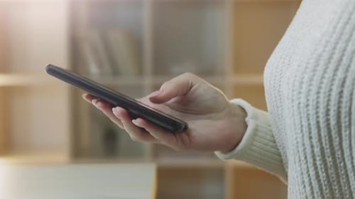 Woman Scrolling on Smartphone at Home