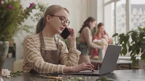 Young Adult Using Laptop and Cellphone in Office