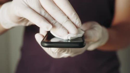 Cleaning a Smartphone with Disinfectant Wipe