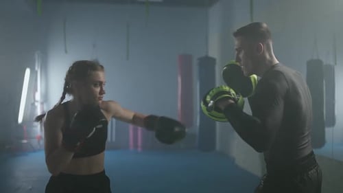 Woman Boxing with Trainer in Indoor Gym