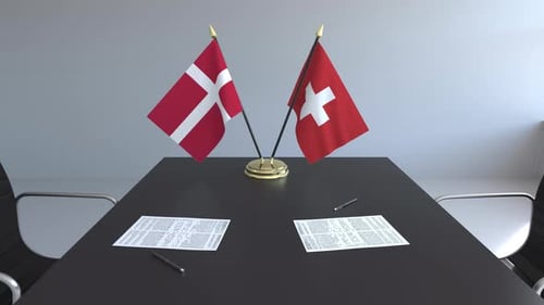 Danish and Swiss Flags on Conference Table for International Business Meeting