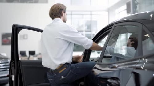 Man Sitting in New Car at Car Dealership