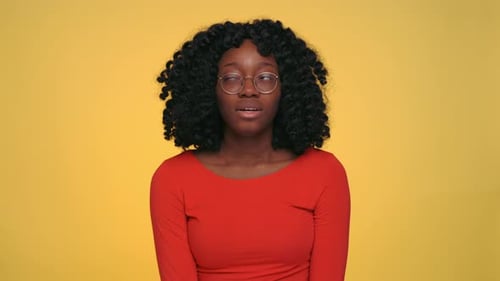 Young Woman Rolls Eyes on Yellow Background