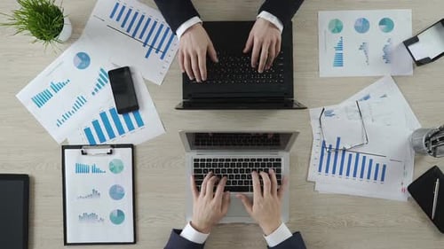 Mains de partenaires commerciaux tapant sur des ordinateurs portables en face de l'autre, négociations