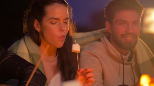 Friends Roasting Marshmallow on Fire at Night Camp