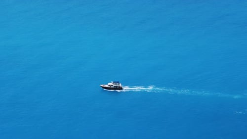 Small Boat Quickly Floating on the Calm Water Surface and Leaving a Trail on the Sea. Video