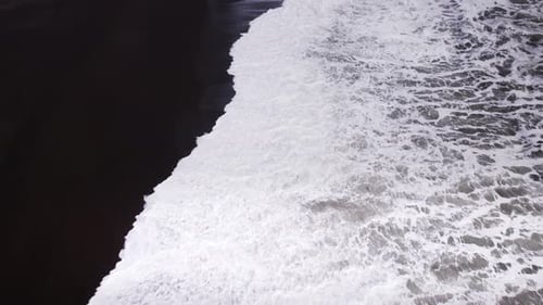Drone Flight Over White Surf Over Black Sand Beach