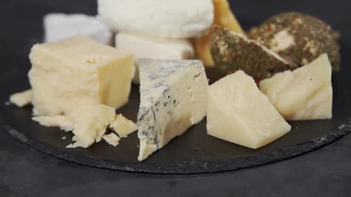 Assortment of Gourmet Cheese on a Black Surface