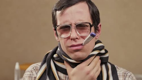 Man with Thermometer Feeling Sick Indoors