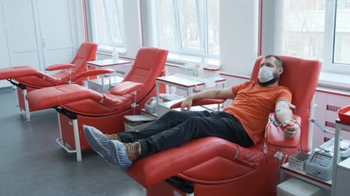 Man Donating Blood in a Hospital Chair