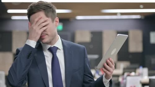 Businessman Reacting to Loss on Tablet in Office