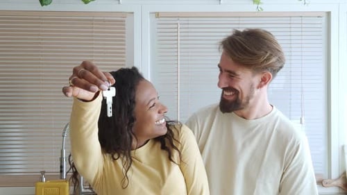 Happy Couple Holding Keys in New Home