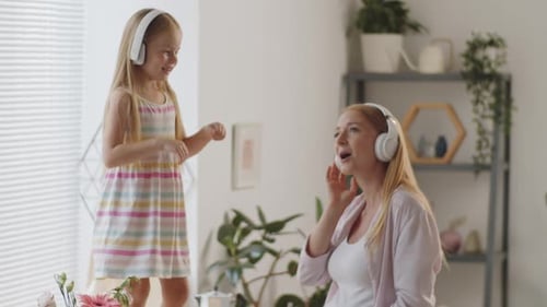 Happy Pregnant Woman and Child Dancing at Home