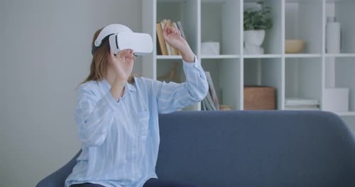 Woman Using VR Headset on Couch in Home