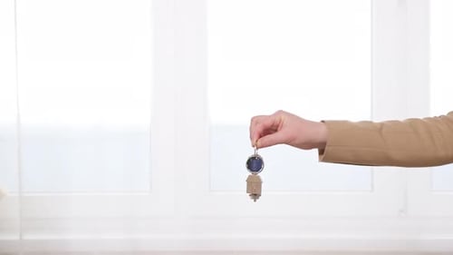 Hands Exchange House Key with House Keychain
