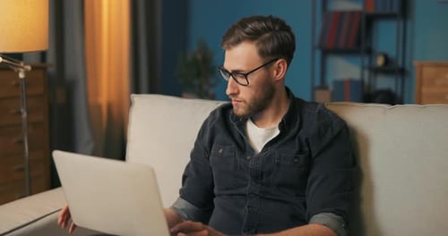 Man Working on Laptop at Home on Couch